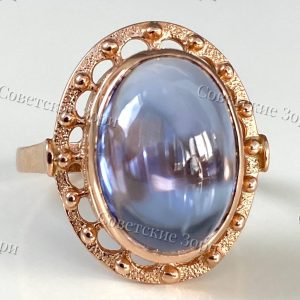 Роскошное золотое кольцо времён СССР с безупречным корундом Сапфира Корунд сапфира в огранке кабошон чаруют мягкой глубиной, словно зеркальная гладь воды, отражающая всё вокруг. Богатая золотая оправа с тонким узором подчеркивает сияние камня.